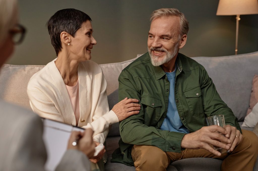 Adult couple smiling happily in successful therapy