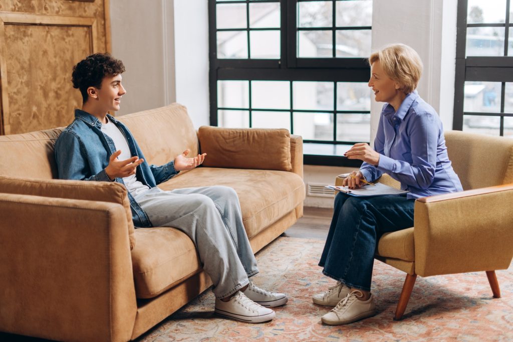 Teen Boy Speaking with Psychologist in a Therapy Session